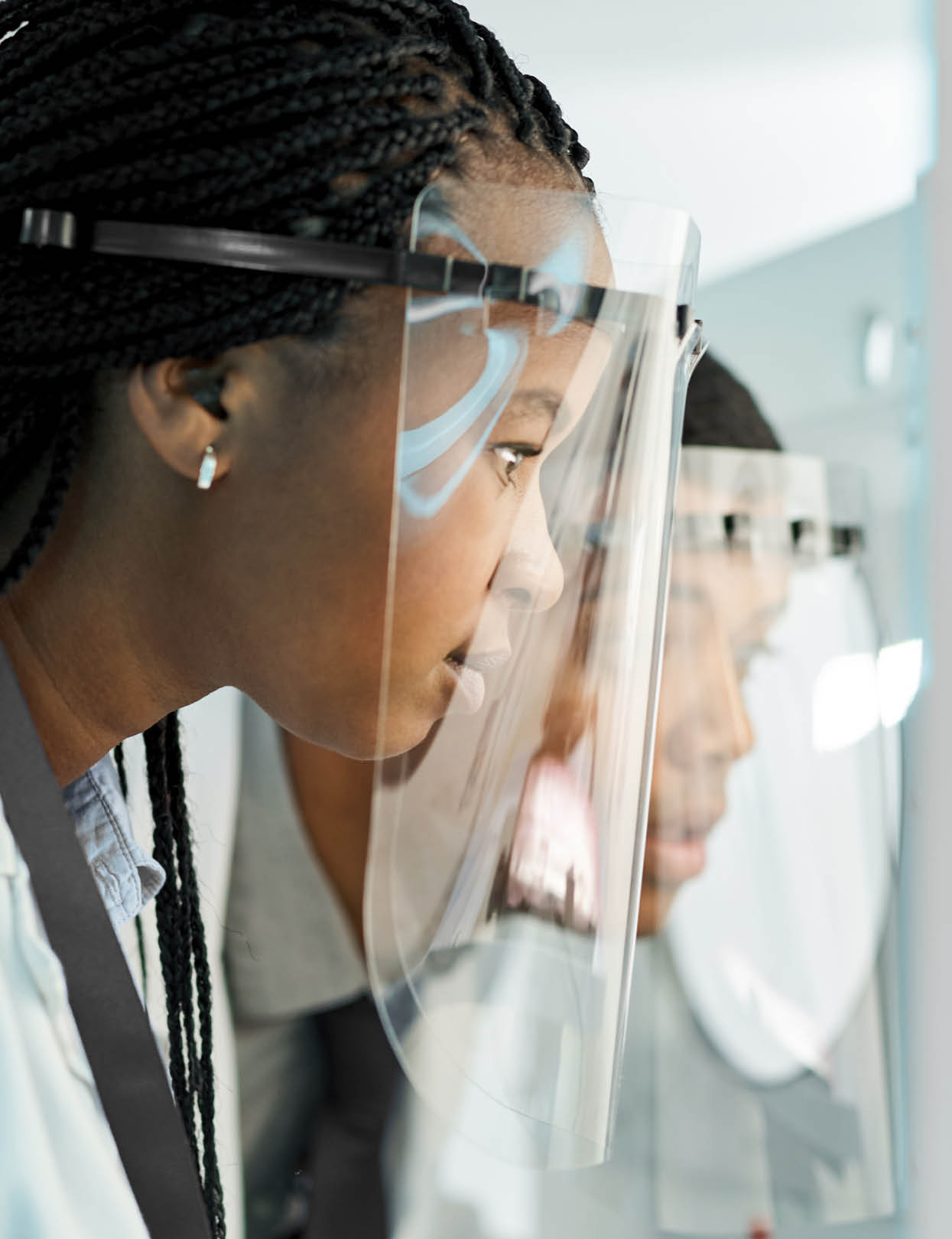 Shot of two scientists wearing face shields while working together in a lab